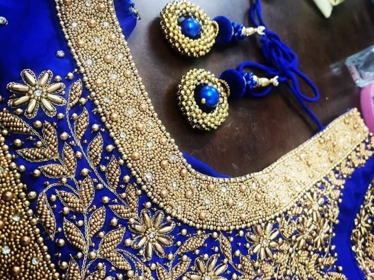 Close up of blue and green embroidered blouse shoulder
